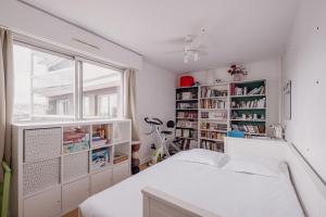 a bedroom with a white bed and a window at Veeve - Home Comforts by the Eiffel Tower in Paris