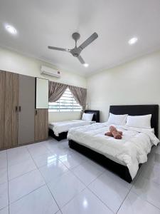 1 Schlafzimmer mit 2 Betten und einem Deckenventilator in der Unterkunft Ipoh Cozy Premium Spacious Home in Ipoh