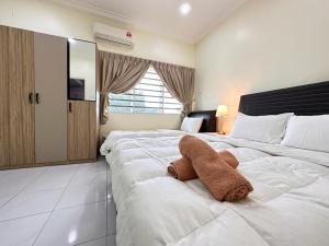 - un grand lit blanc avec un animal rembourré dans l'établissement Ipoh Cozy Premium Spacious Home, à Ipoh