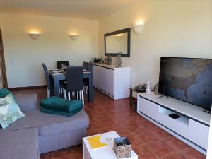 a living room with a couch and a tv and a table at Eden Jasmim by FHR in Quarteira