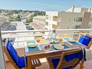 una mesa en un balcón con vistas a la ciudad en Eden Jasmim by FHR en Quarteira
