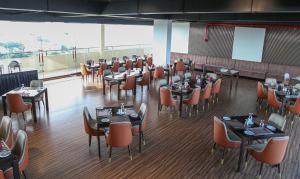 um restaurante com mesas e cadeiras num quarto em Ocean Breeze Studio Apartment Negombo em Negombo