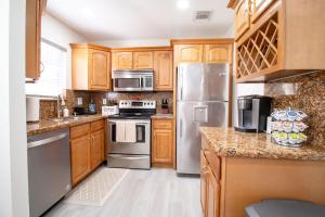 a kitchen with wooden cabinets and stainless steel appliances at Good Vibes Oasis - Cozy townhome with parking in Cutler Bay