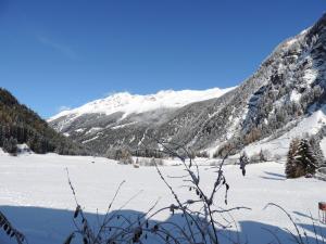 a view of a snow covered mountain with a lake at Haus Renate in Kaunertal