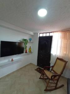 a living room with a chair and a flat screen tv at Agradable Apto San Luis in Bucaramanga