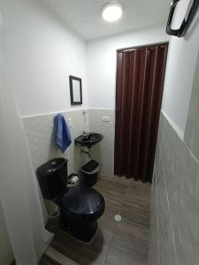 a bathroom with a black toilet and two sinks at Agradable Apto San Luis in Bucaramanga
