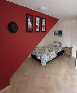 a bedroom with a bed and a red wall at Agradable Apto San Luis in Bucaramanga