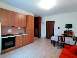 a kitchen with wooden cabinets and a table with a red couch at Sweet Lorica in Lorica