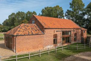 un antiguo edificio de ladrillo con techo naranja en Kings Beck Barn en Norwich