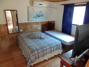 a bedroom with a bed and a tv and a mirror at Villaggio di Assisi in São Sebastião