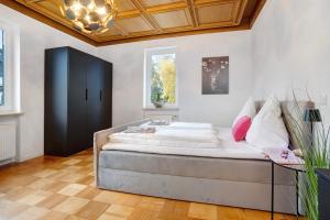 a bedroom with a bed with white sheets and pink pillows at Goldberg in Grünstadt