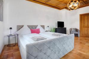 a bedroom with a large bed with white sheets and pink pillows at Goldberg in Grünstadt