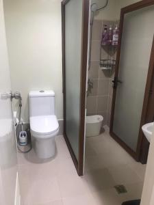 a white bathroom with a toilet and a sink at Brenthill Condominium in Baguio