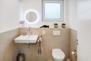 a bathroom with a sink and a toilet and a window at Goldberg in Grünstadt