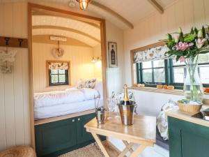 a small room with a small table and a bed at Poppie's Shepherds Hut in Nottingham