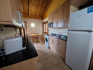 uma cozinha com um frigorífico branco e uma mesa em Can Jorge em Camprodon