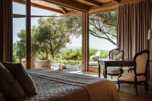 een slaapkamer met een bed, een bureau en een raam bij Boutique Hotel - Poggio ai Santi in San Vincenzo