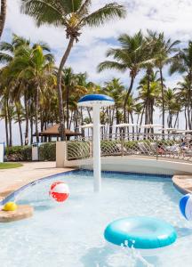 a swimming pool at a resort with palm trees at Caribe Hilton in San Juan
