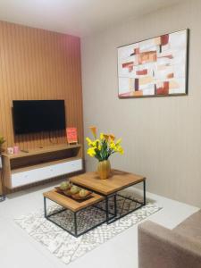 a living room with a coffee table and a television at Brenthill Condominium in Baguio