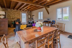 Gîte de charme, idéal pour 4 في Saint-Jory-de-Chaleix: غرفة معيشة مع طاولة وكراسي خشبية