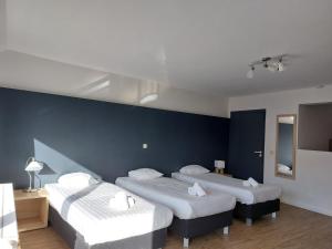 three beds in a room with blue walls at Room in Studio - Value Stay Residence Mechelen - Studio Triple in Mechelen