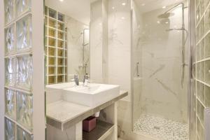 a white bathroom with a sink and a shower at Appartement de standing Cannes in Cannes