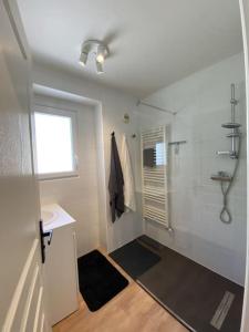 een witte badkamer met een douche en een wastafel bij Magnifique Appart rénové Evian vue Lac 8 pers in Évian-les-Bains