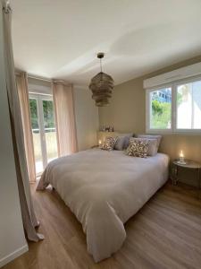 een slaapkamer met een groot bed en 2 ramen bij Magnifique Appart rénové Evian vue Lac 8 pers in Évian-les-Bains