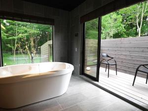 a large bath tub in a bathroom with a patio at Rakuten Stay Villa 日光 in Nikko