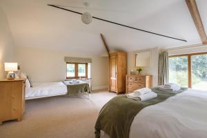 a bedroom with two beds and a window at Kings Beck Barn in Norwich