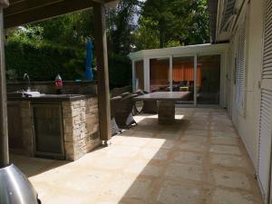 an outdoor patio with a grill and a table at Villa de 4 chambres avec piscine privee et wifi a Maule in Maule