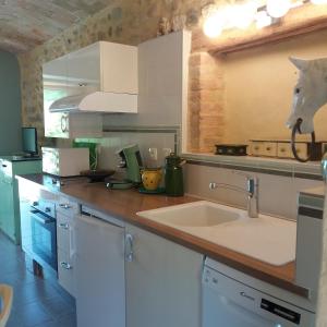 cocina con fregadero y encimera en Gîte avec jacuzzi privatif dans un mas provençal, en Les Fumades-Les Bains