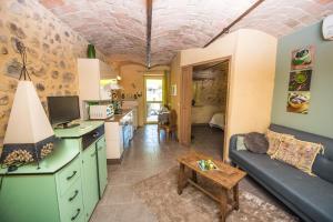 cocina y sala de estar con sofá y mesa en Gîte avec jacuzzi privatif dans un mas provençal, en Les Fumades-Les Bains