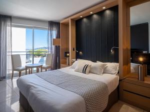 a bedroom with a large bed and a large window at Hotel Revellata & Spa in Calvi +122 photos