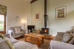 uma sala de estar com um fogão a lenha num quarto em Kings Beck Barn em Norwich