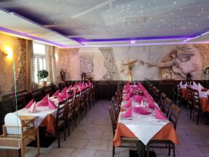 a dining room with tables and chairs with pink napkins at Hotel im Gässle in Süßen