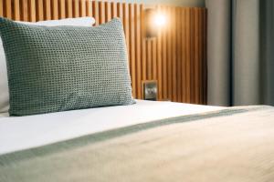 a bed with a green pillow on top of it at Haslem Hotel in Lisburn