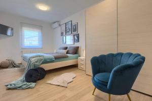um quarto com uma cama e uma cadeira azul em Wonderful Villa Mattuzzi with private pool near the town em Pula