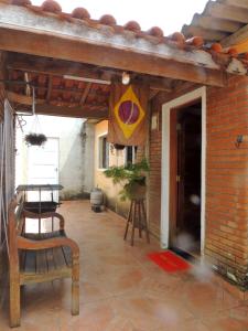 a patio with a table and a chair and a brick wall at Villaggio di Assisi in São Sebastião