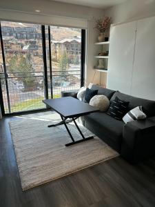 a living room with a black couch and a table at YotelPAD Park City Unit #432 in Park City
