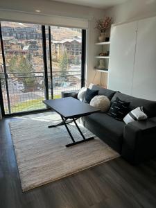 sala de estar con sofá negro y mesa en YotelPAD Park City Unit #432, en Park City