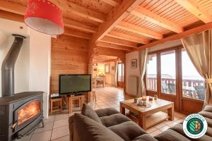 sala de estar con sofá y chimenea en ST JORIOZ- Cosy Chalet vue lac et montagnes - LLA Selections by Location Lac Annecy, en Saint-Jorioz