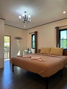 a large bed in a bedroom with a chandelier at Hanoii House in Ko Mak