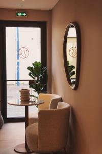 a room with a chair and a table and a mirror at Villa Chiesa in Le Grau-du-Roi