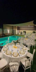 a dining room with a table and a swimming pool at Moon light in Sharīyah