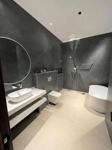 ein Badezimmer mit einem Waschbecken, einem WC und einem Spiegel in der Unterkunft Moon light in Sharīyah