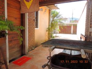 a porch of a house with a bench and a table at Villaggio di Assisi in São Sebastião