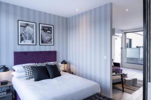 1 dormitorio con 1 cama blanca grande con cabecero púrpura en NEW & Spacious - Private Balcony - Station Nearby en Farnborough