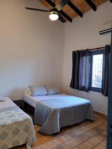 - une chambre avec 2 lits et une fenêtre dans l'établissement Casa colonial a metros del arroyo Piribebuy, à Piribebuy