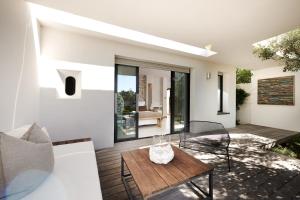a living room with a wooden table on a patio at Hôtel Cala di Greco in Bonifacio